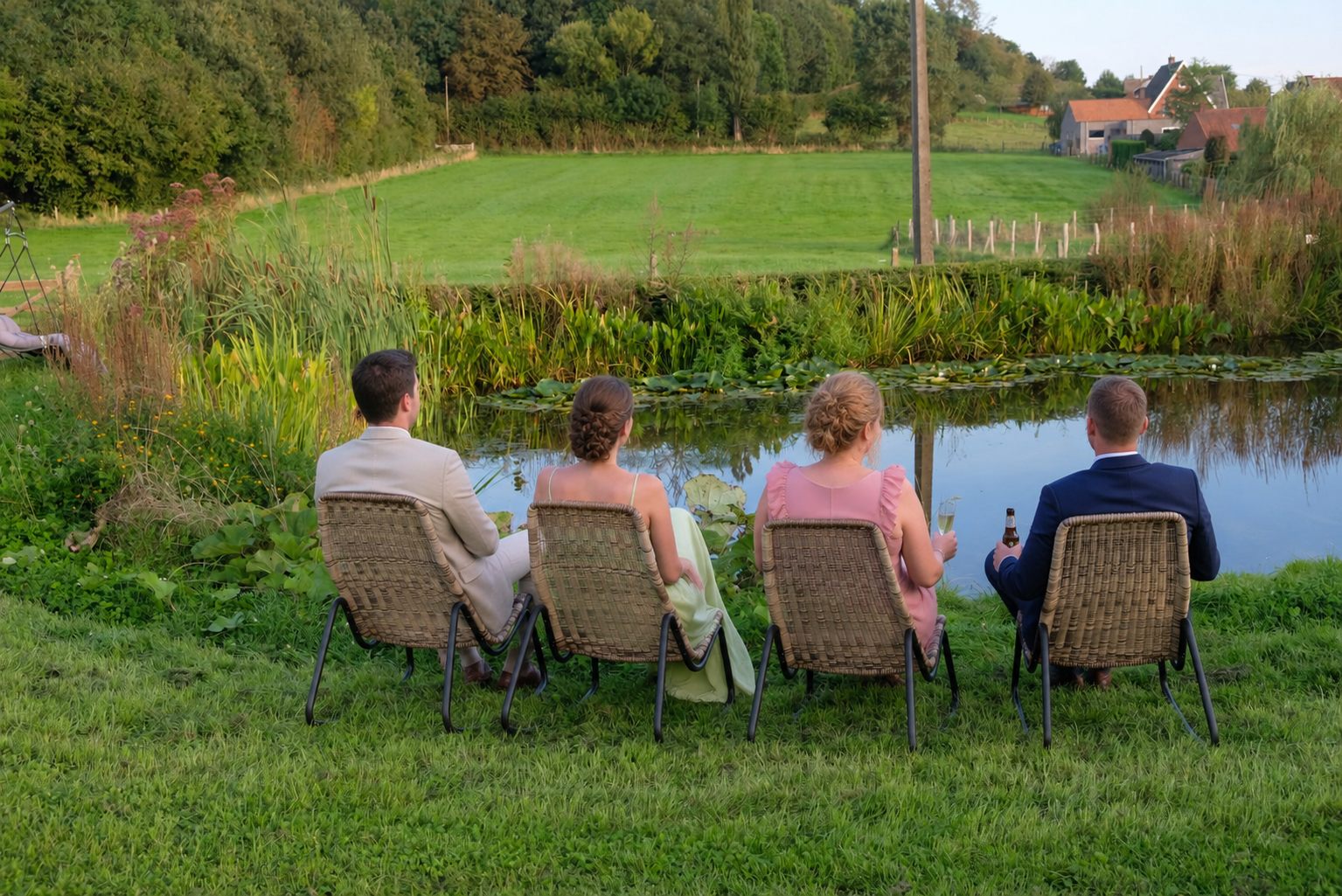 Gasten genieten van een drankje aan de vijver