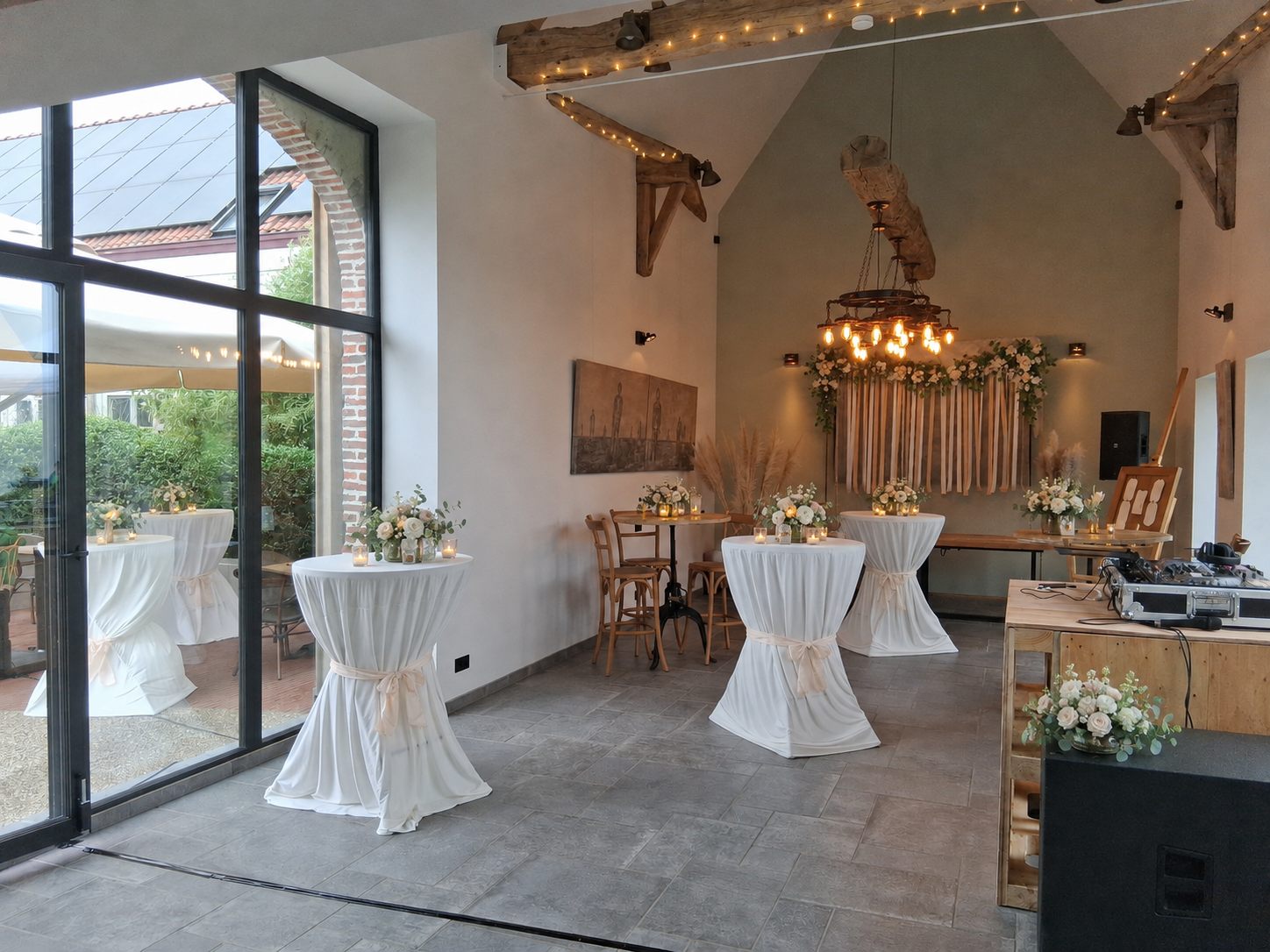 Versierde trouwzaal met statafels en bloemen